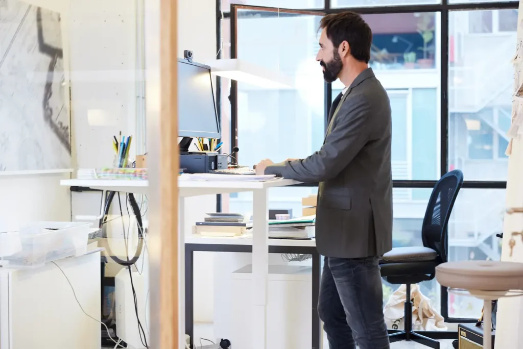 Office worker standing and working using a standing desk