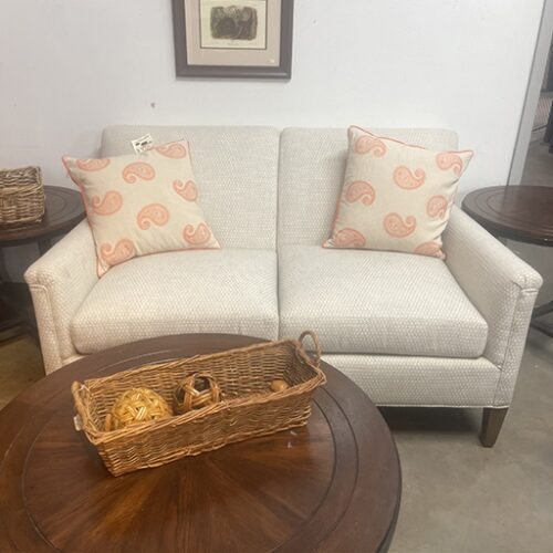 A couch and table with a basket on top, displayed at the Office Furniture Expo in Atlanta, GA.